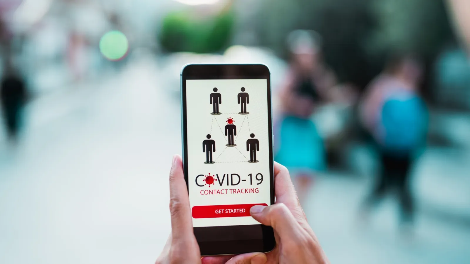 Hands holding a smart phone, looking at a COVID-19 tracing app